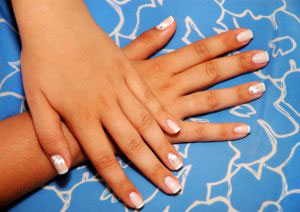 female hands with neat manicure resting calmly on table top