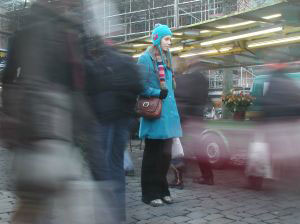 woman standing still in rushing crowd